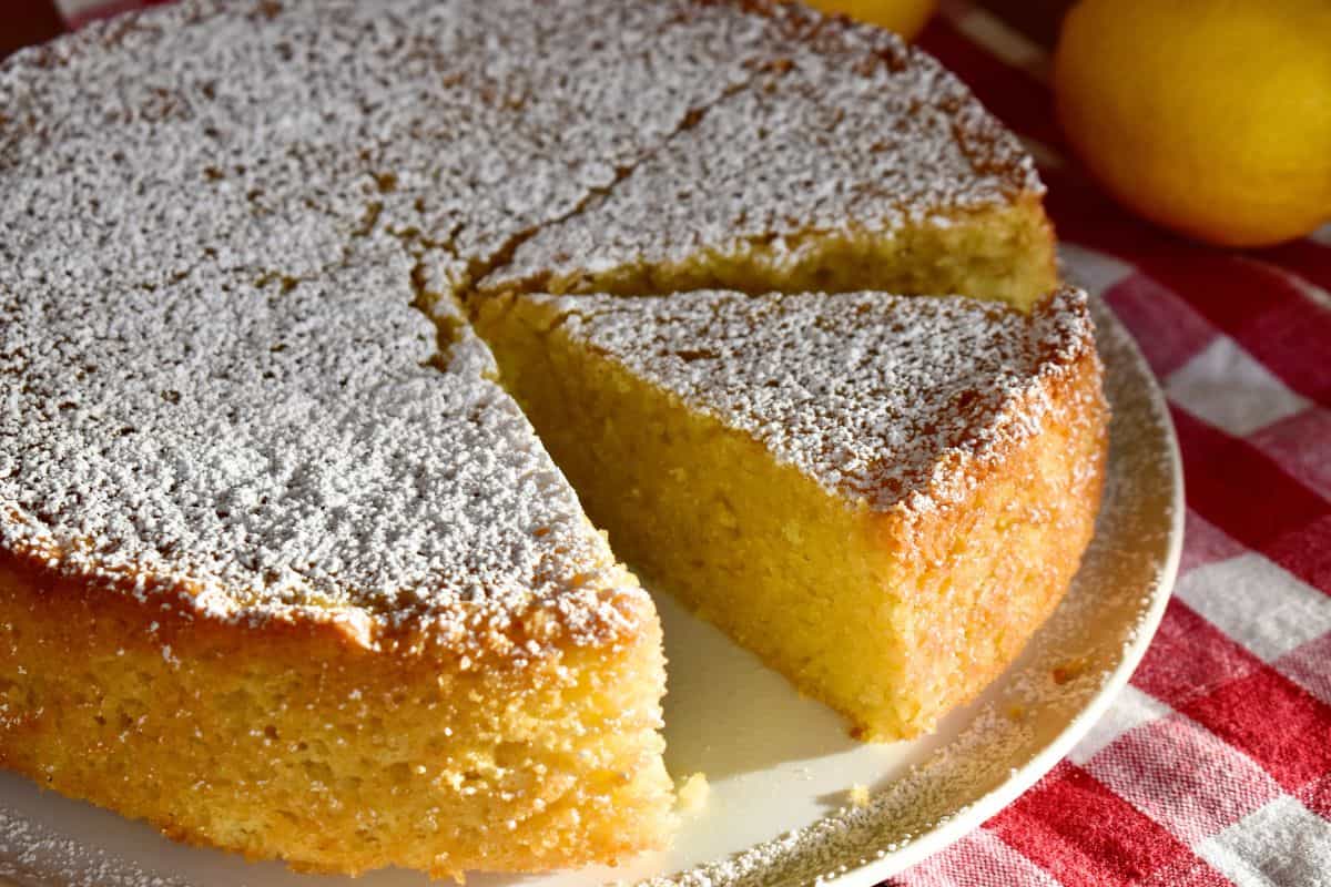 Italian Lemon Olive Oil cake on a white plate with powdered sugar on top. 