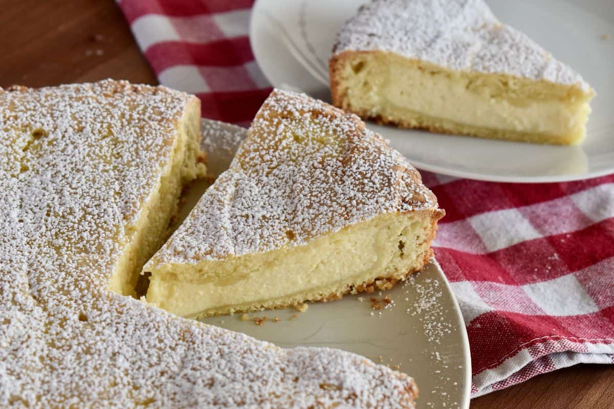 Ricotta Pie on a serving plate with powdered sugar sprinkled on top. 