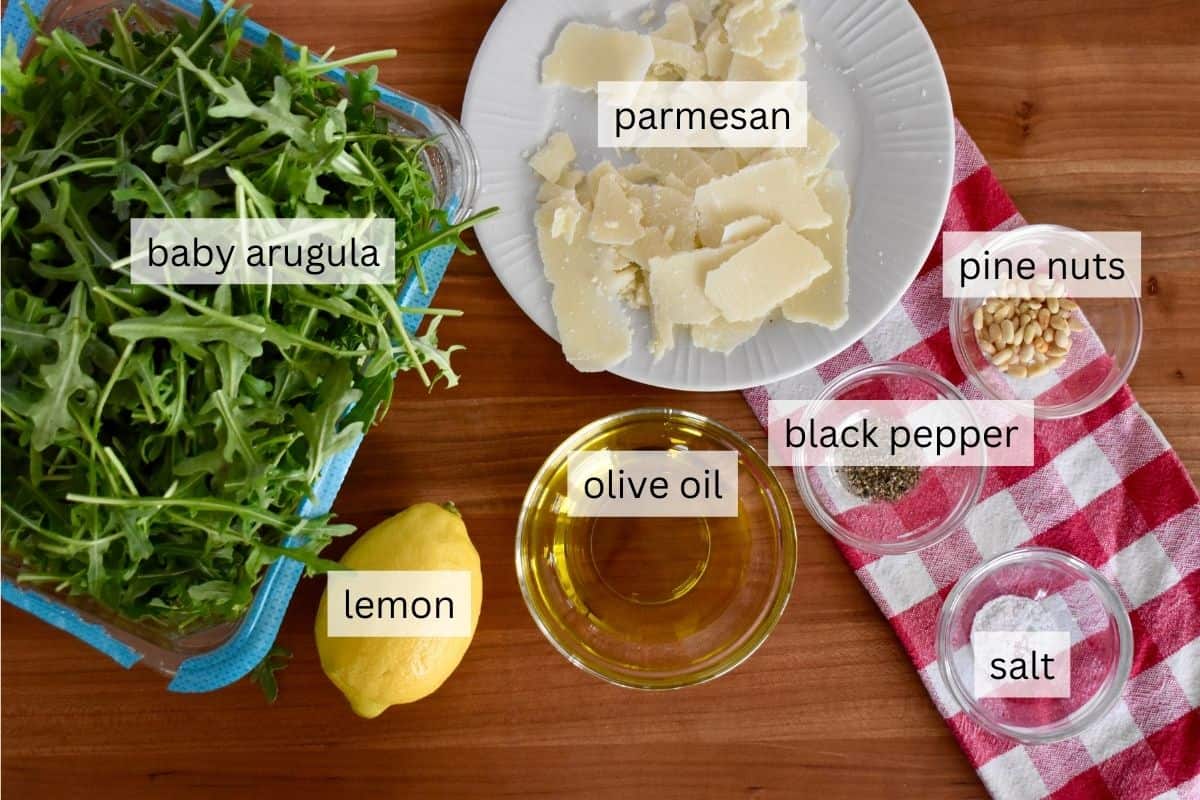Ingredients including parmesan cheese, lemon, olive oil, and pine nuts. 