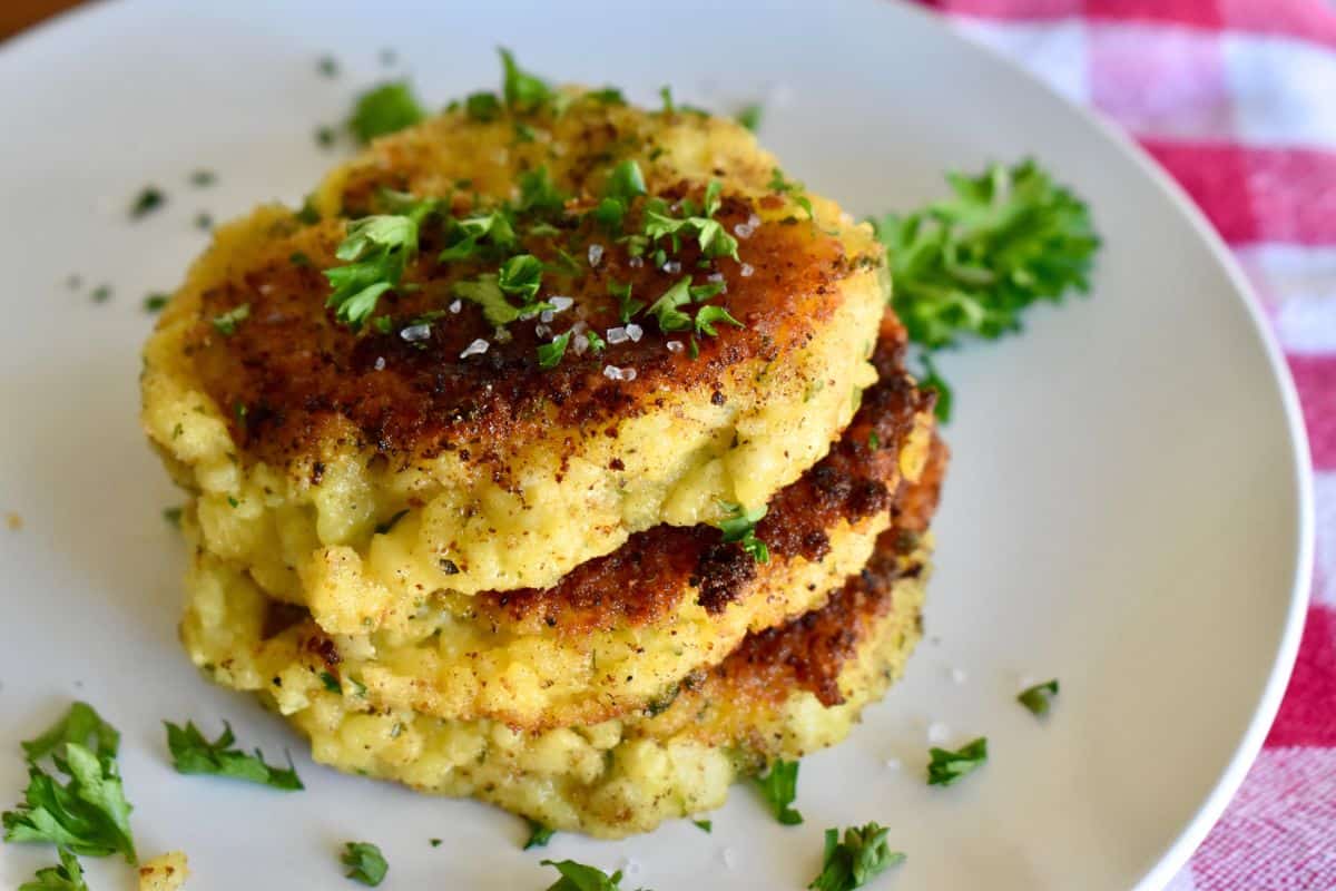 Risotto Cakes on a white plate with parsley on top. 