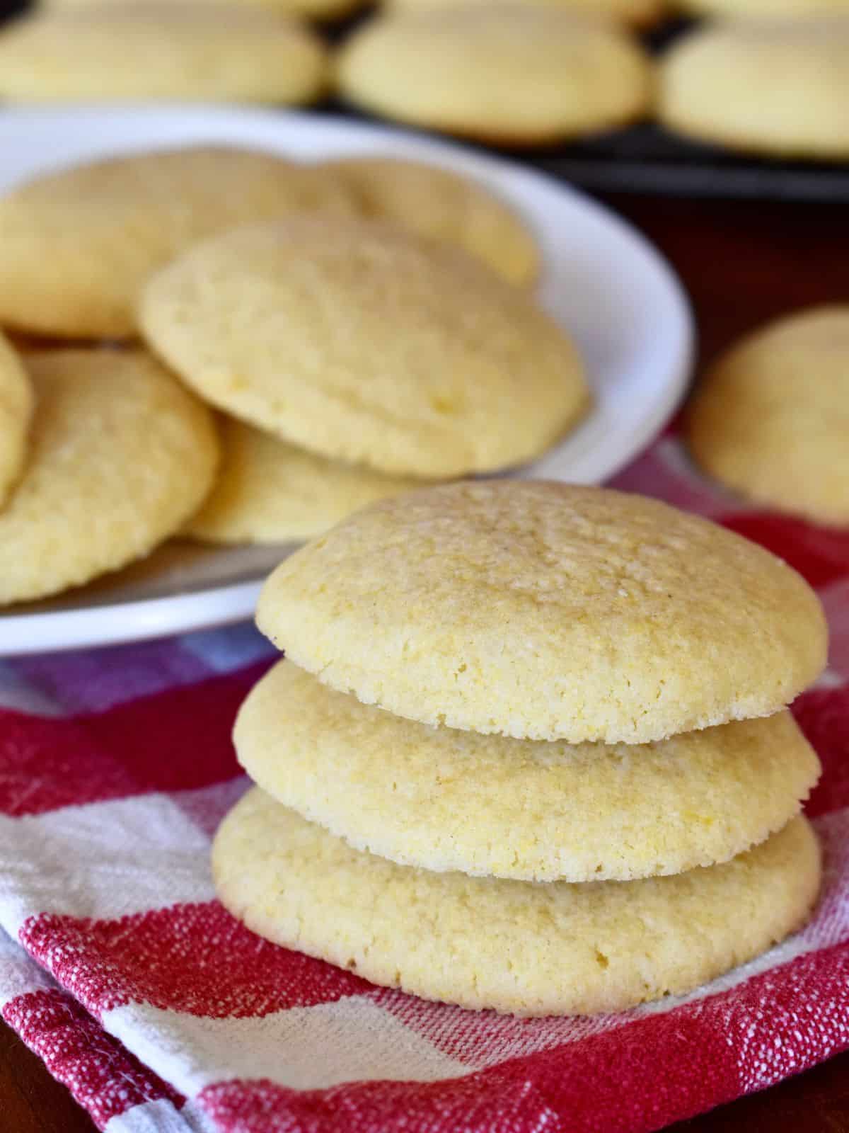 Italian cornmeal cookies stacked on each other on a red checkered napkin. 