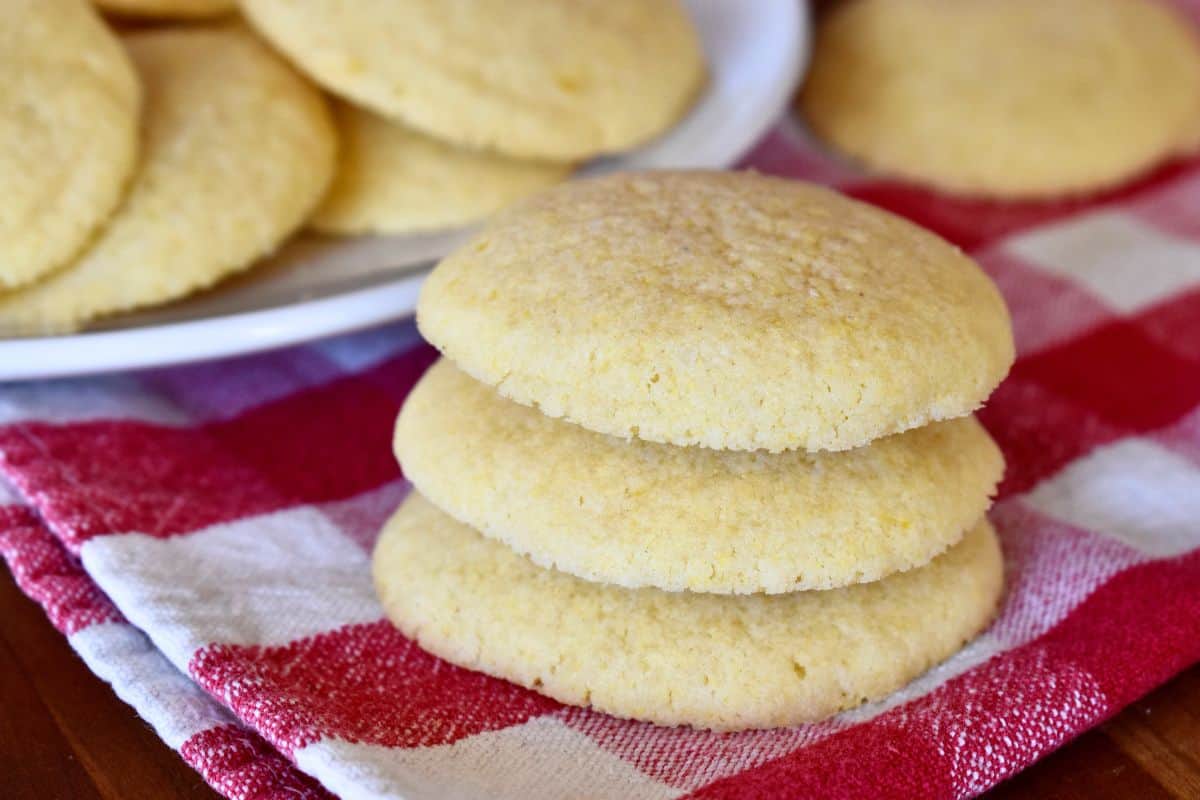 Italian Cornmeal Cookies stacked on a checkered napkin. 