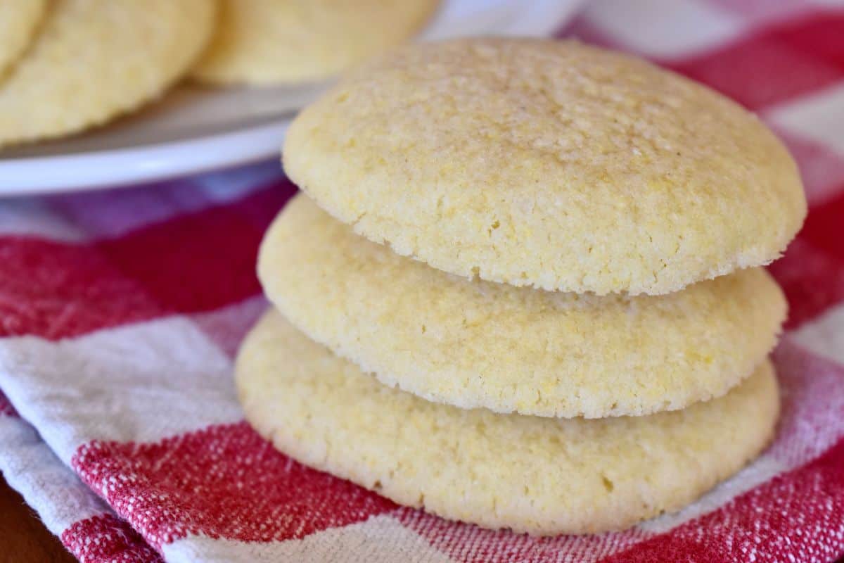 Italian cornmeal cookies from the Piemdont region stacked on each other on a checkered napkin. 