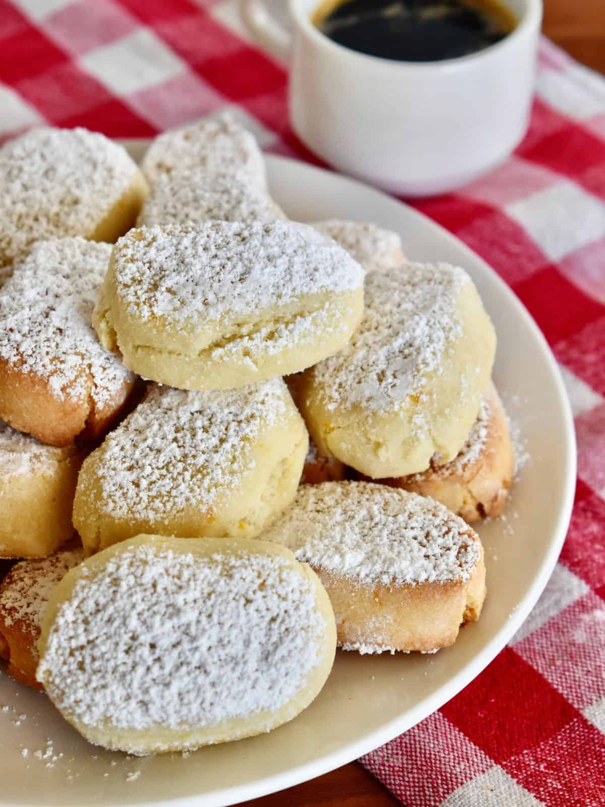 Italia Almond Cookies on a white plate with a checkered napkin underneath. 