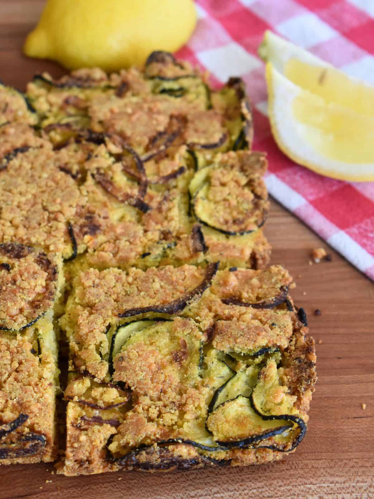 Zucchini Scarpaccia on a counter with a lemon slice next to it. 