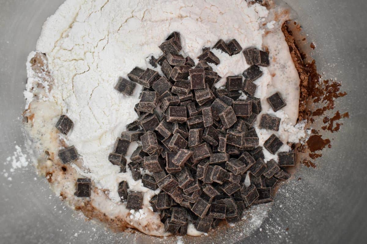 Metal bowl with ingredients including flour and proofed yeast. 