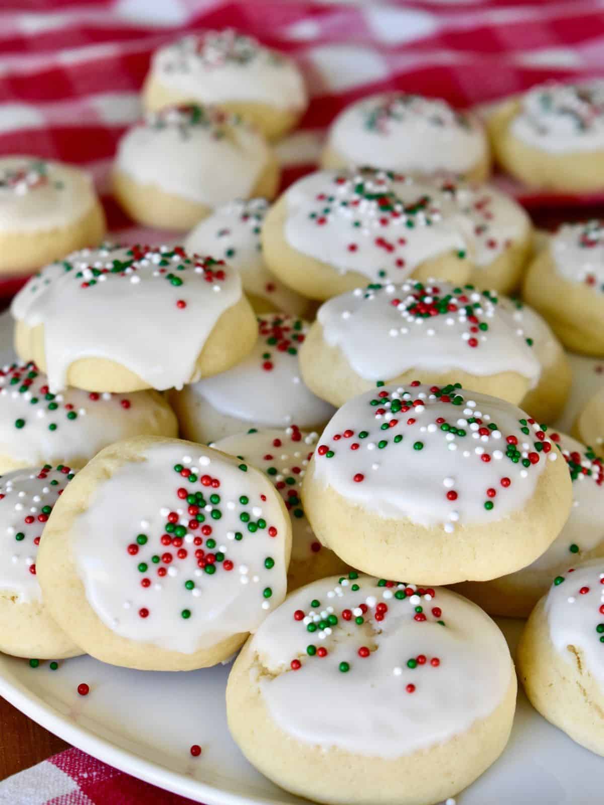 Italian Christmas Cookies with red and green sprinkles on a white plate. 