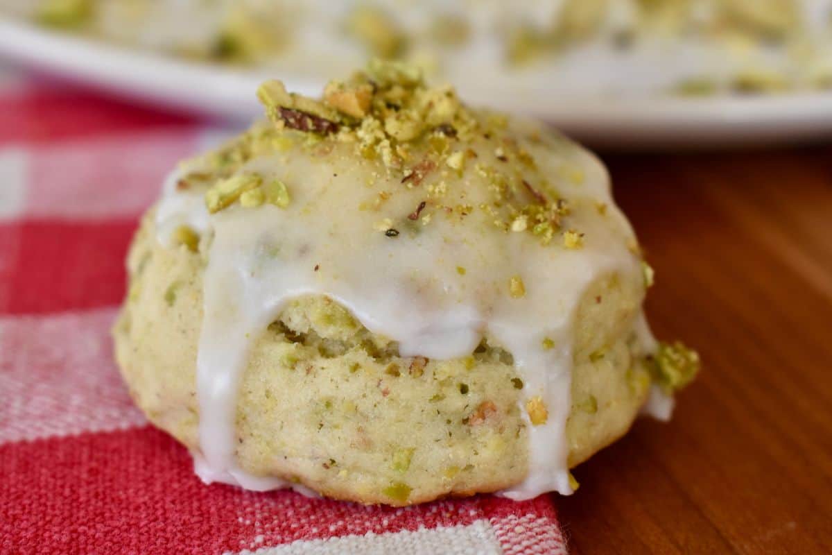 Pistachio Ricotta Cookie with frosting on a checkered napkin. 