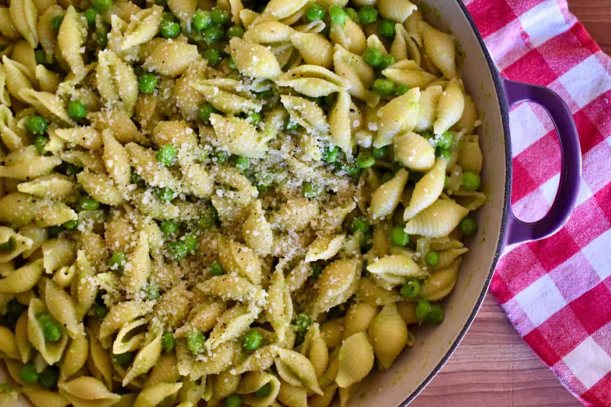 Pasta e Piselli in a large dutch oven skillet on a checkered napkin. 