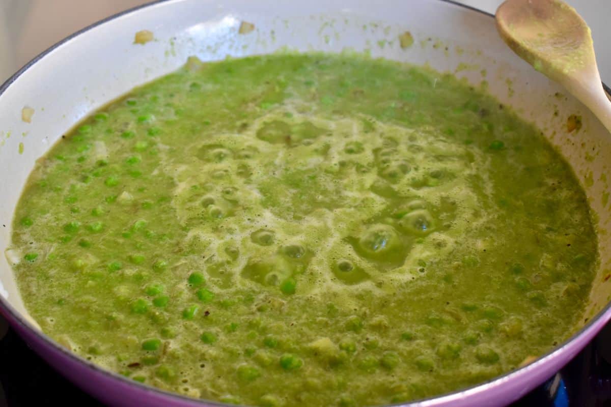 Pureed pea sauce simmering in a large dutch oven. 