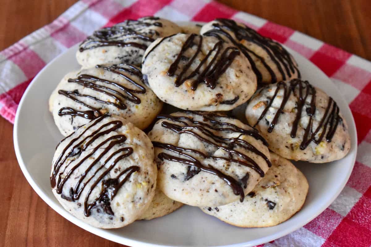 Cannoli Cookies on a white plate with dark chocolate drizzle over top.