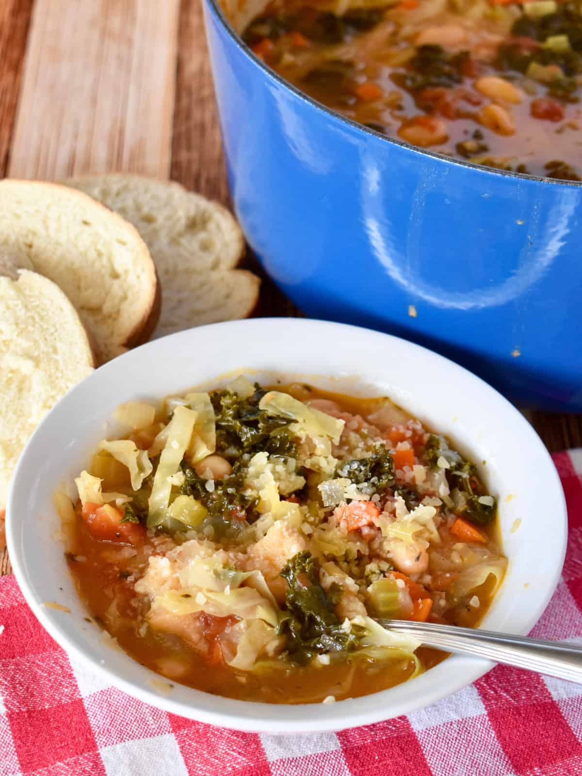 Ribollita Tuscan Bread Soup in a white bowl with a spoon. 