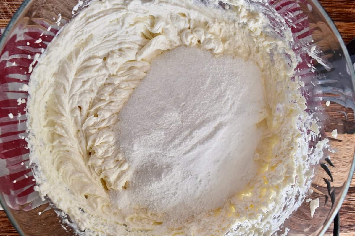 Filling for the recipe in a glass bowl with sugar cornstarch mixture on top. 