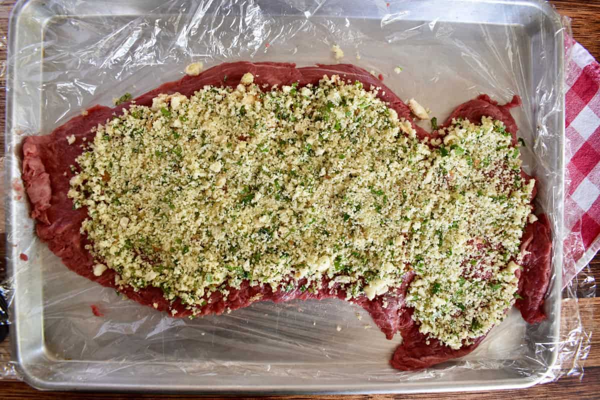 Breadcrumb mixture spread on top of the flank steak. 