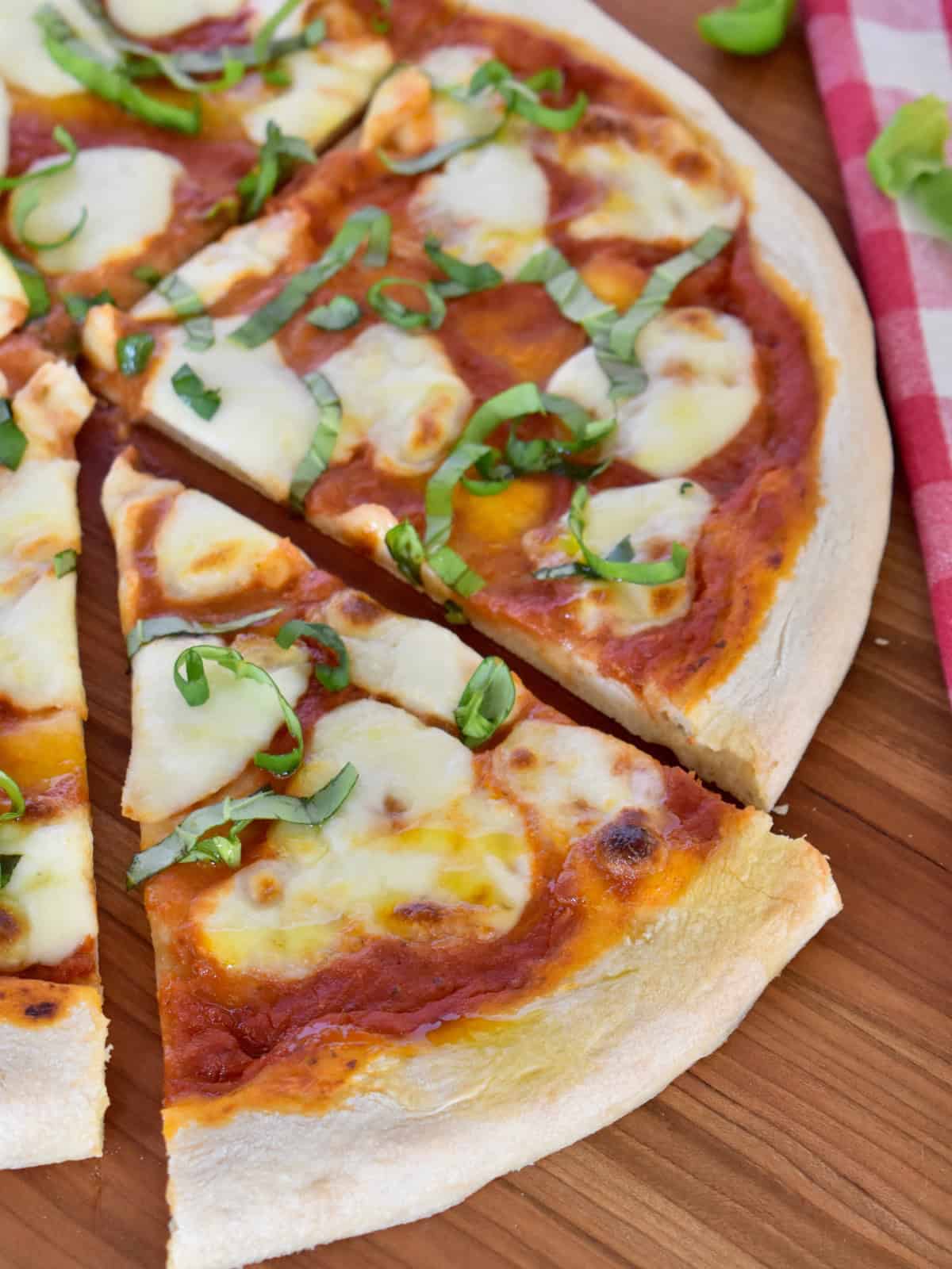 Slice of Italian Margherita Pizza with mozzarella and basil. 