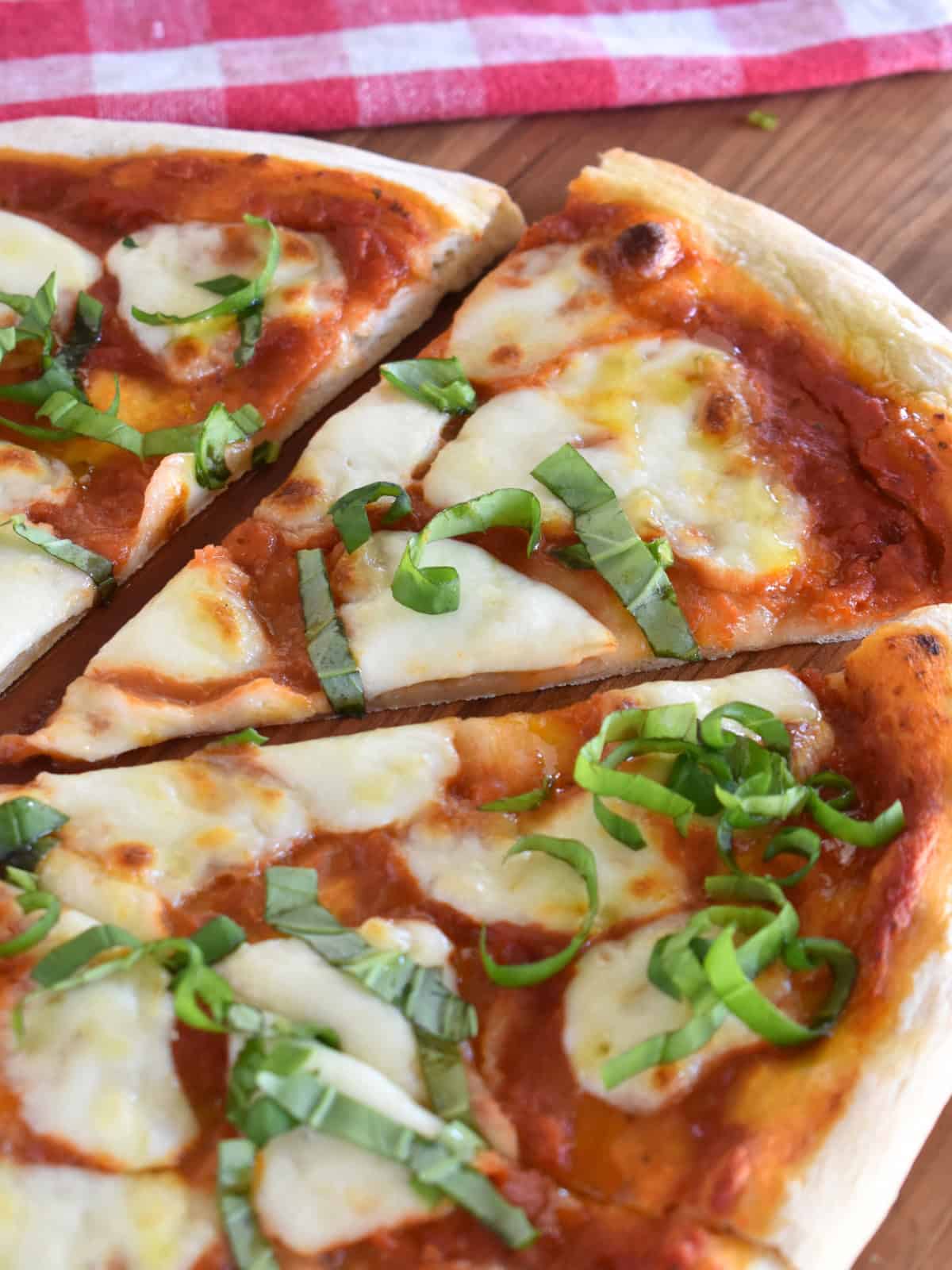 Slice of Italian Margherita pizza on a cutting board. 