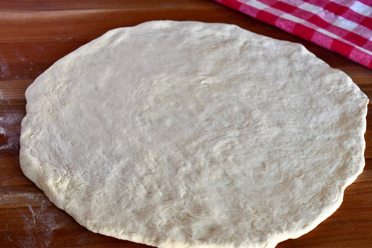 Pizza dough stretched into a round shape. 