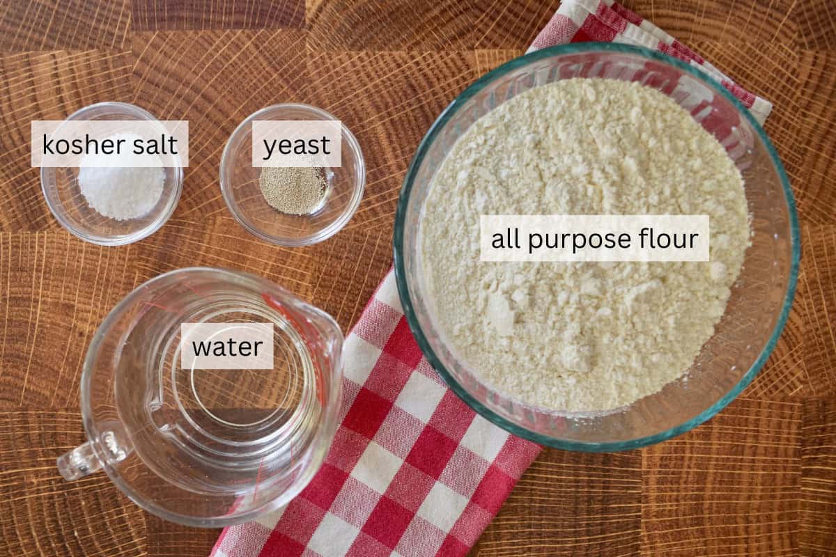 Flour, water, salt, and yeast on a countertop. 