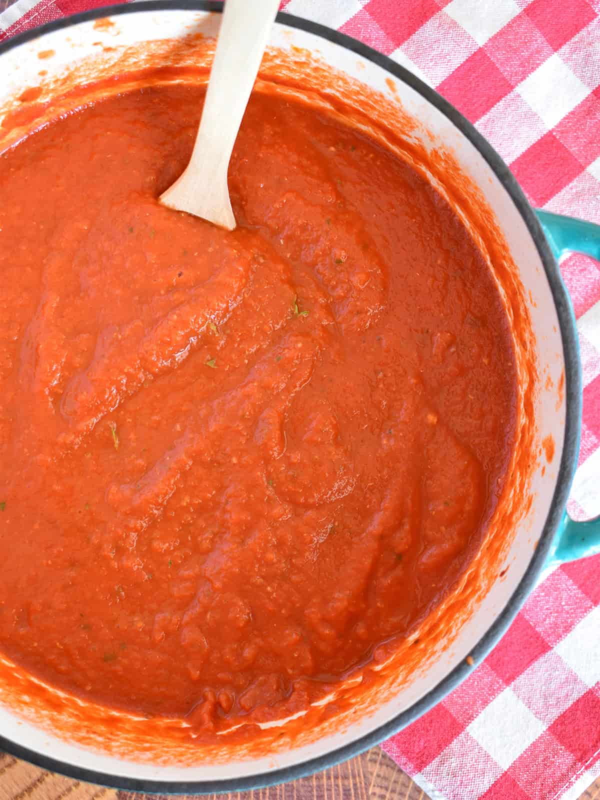 Simple Marinara Sauce recipe in a dutch oven with a spoon. 