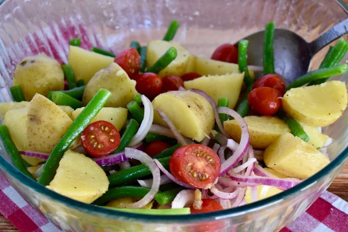 Ingredients for Italian Potato Salad in a large glass bowl. 