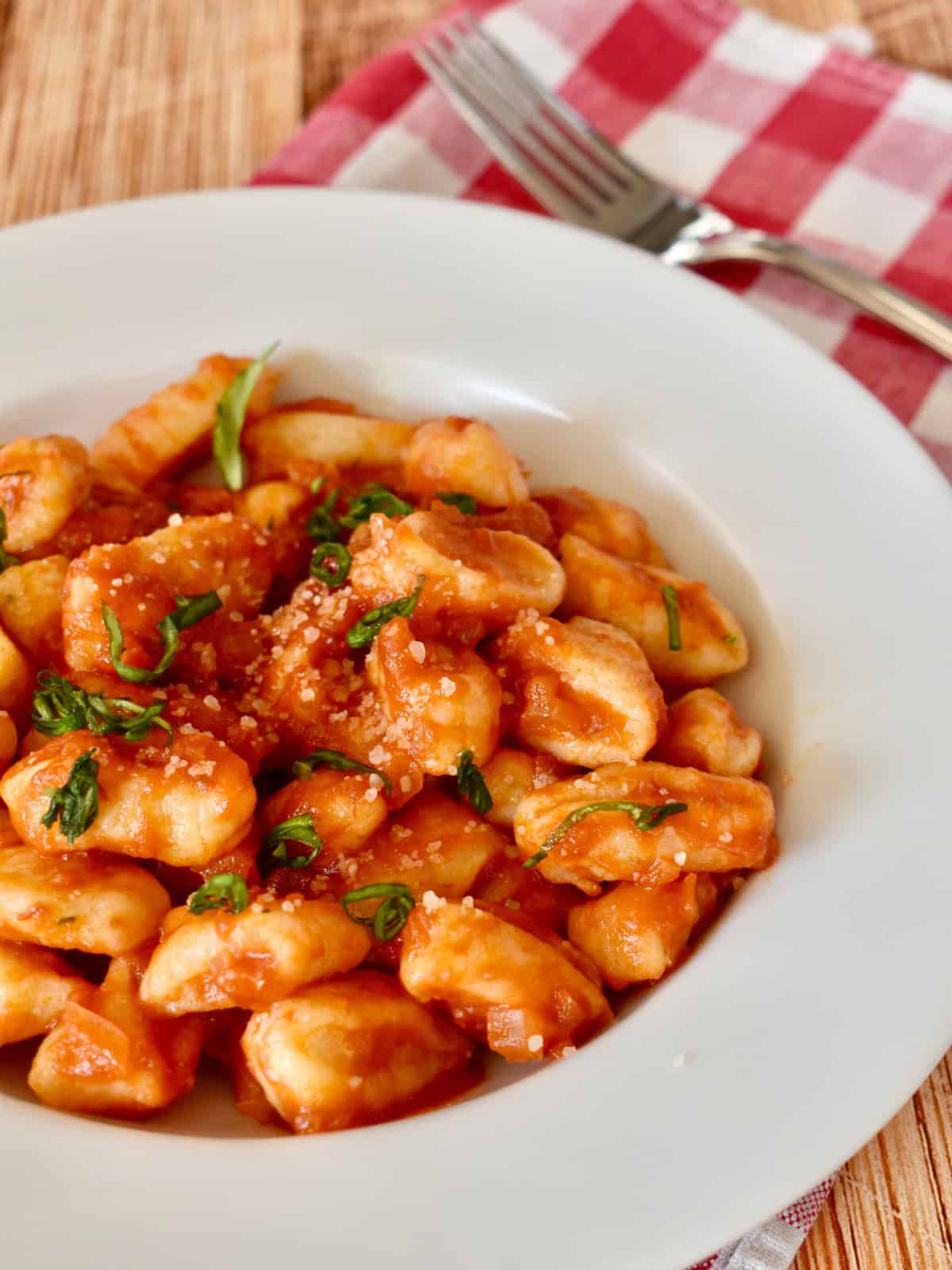 Ricotta Gnocchi with red sauce in a white bowl.