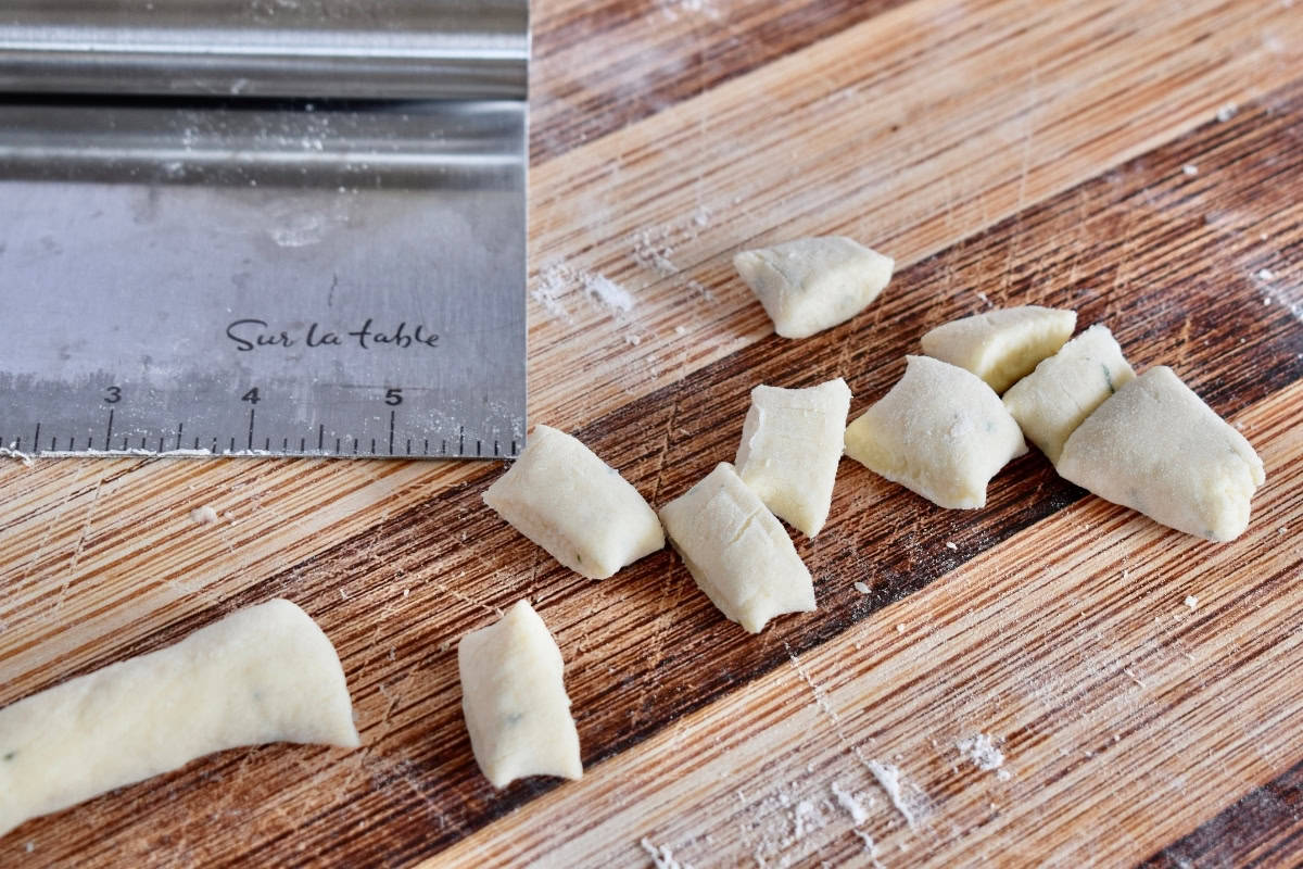Cut dough on a wood cutting board. 