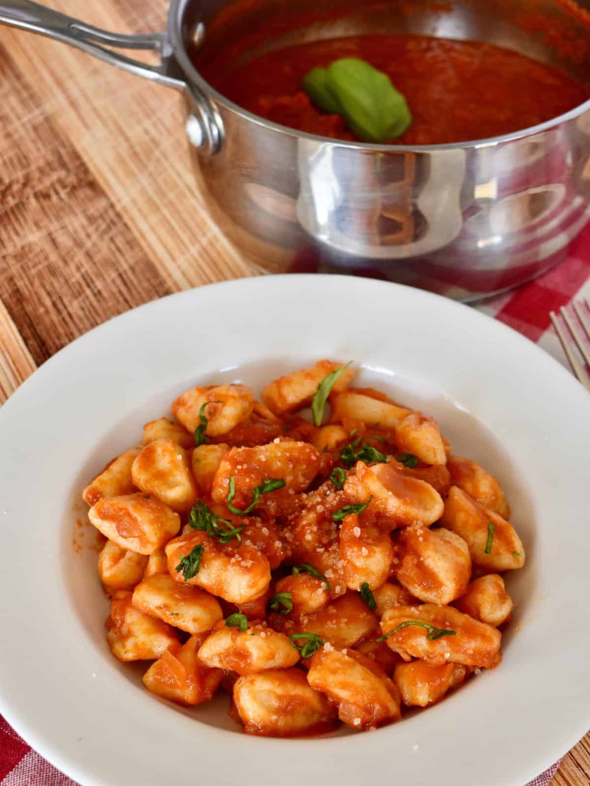 Gnocchi with tomato butter sauce in a white bowl. 