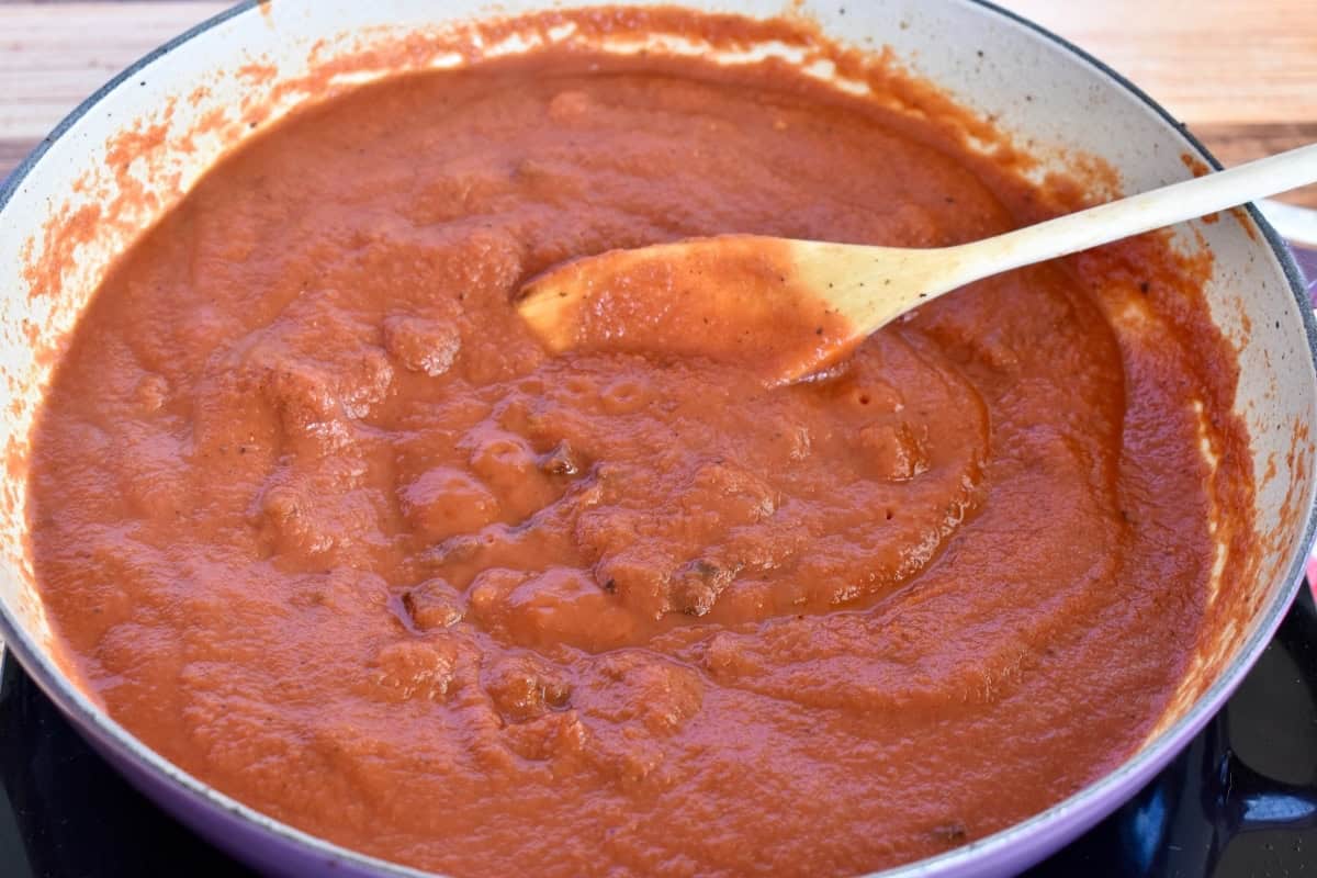 Amatriciana sauce in a pan with a wooden spoon. 