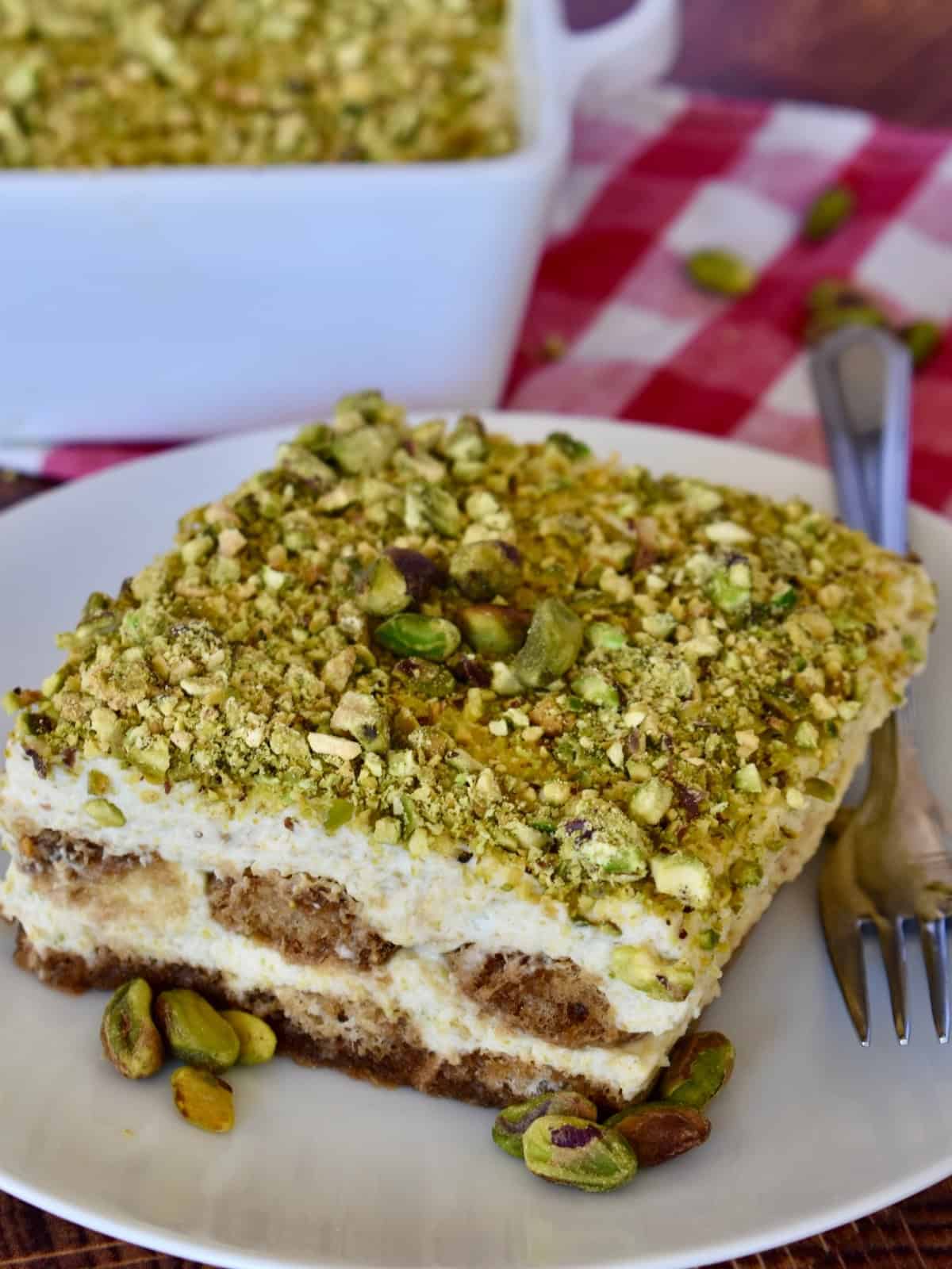 Pistachio tiramisu on a white plate. 
