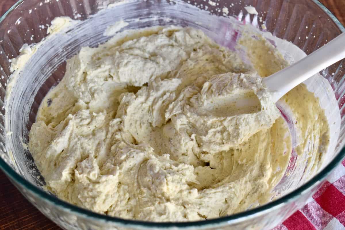 Whipped cream and mascarpone in a large glass mixing bowl. 