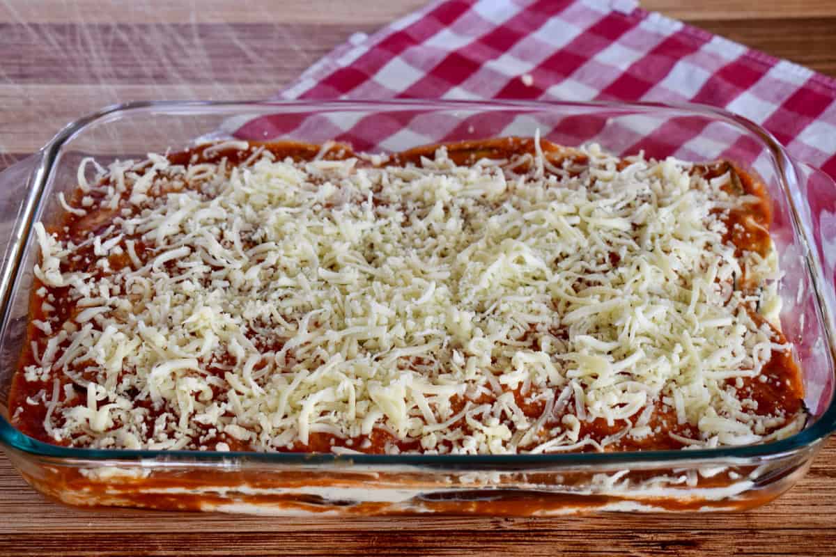 Shredded cheese on top of the recipe in a baking dish. 