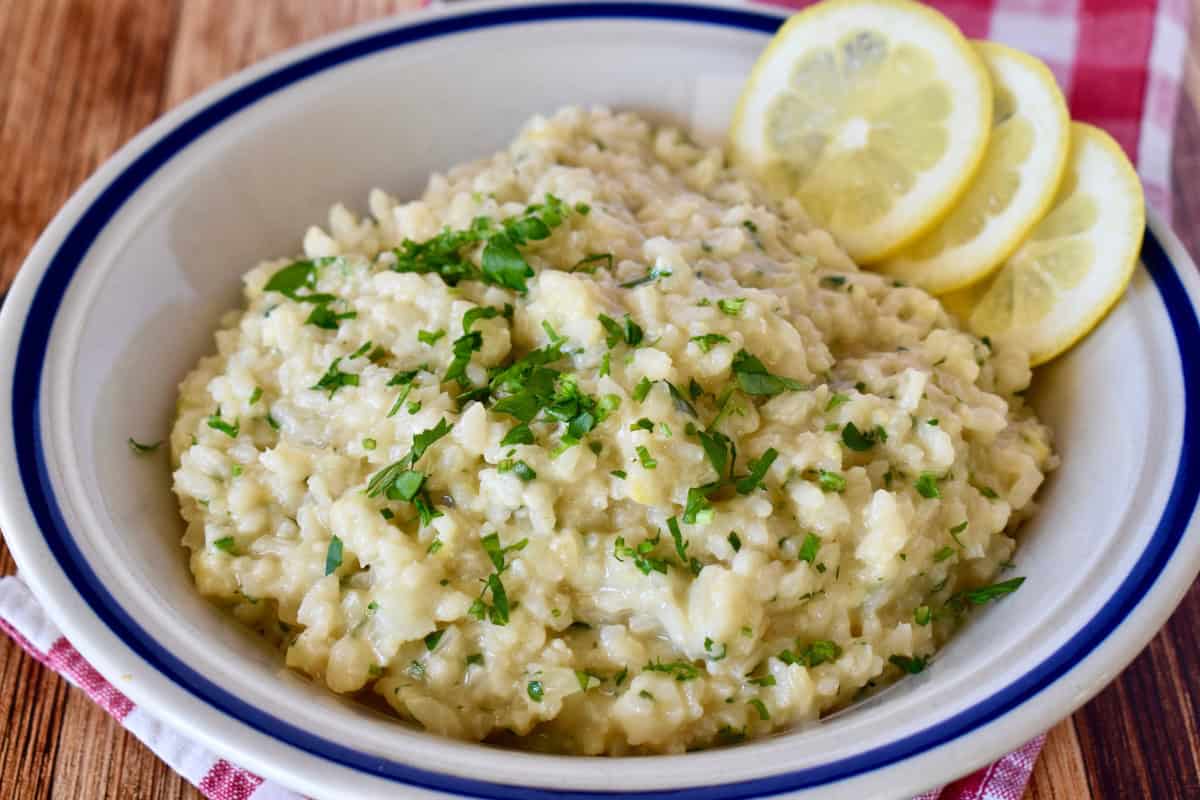 Lemon Risotto with lemon slices in a white bowl. 