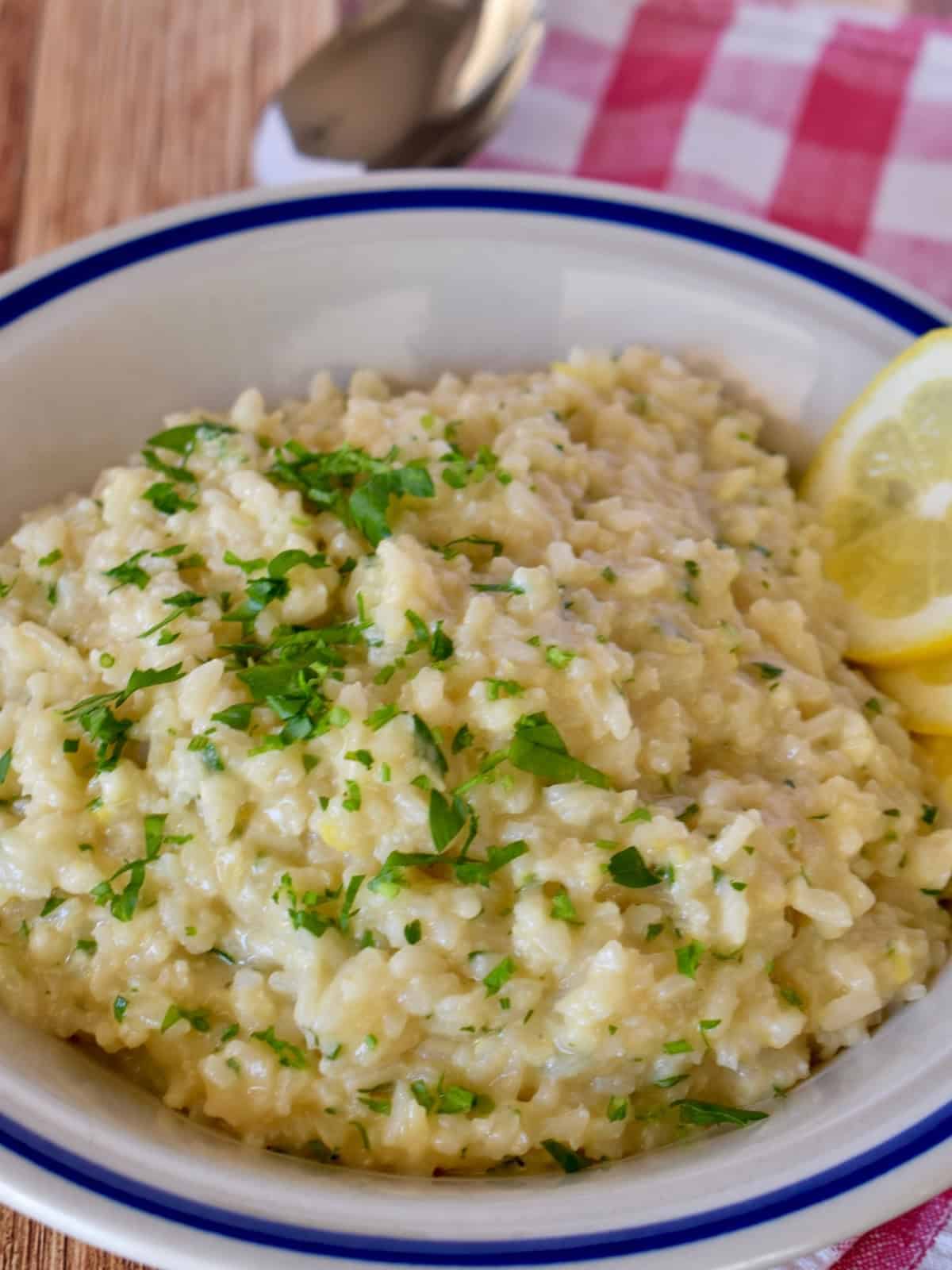 Lemon Risotto in a white bowl with a spoon.