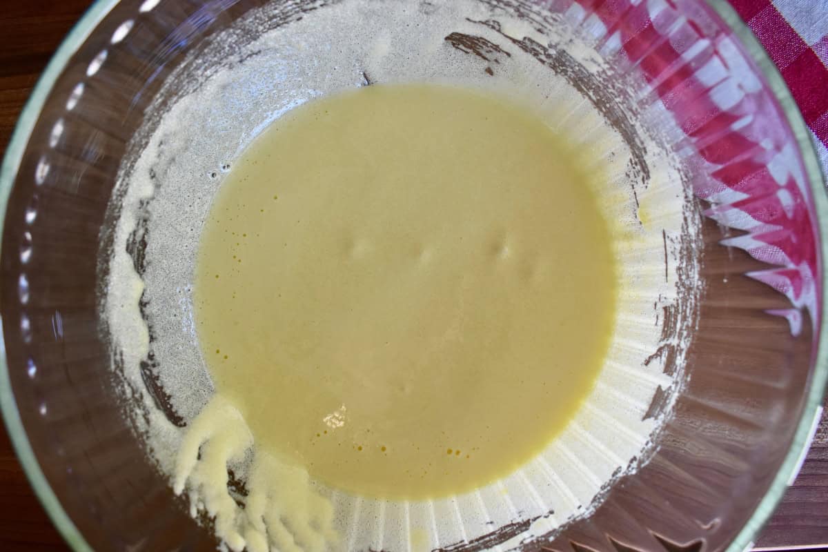 Egg yolks and sugar mixed together in a glass bowl. 
