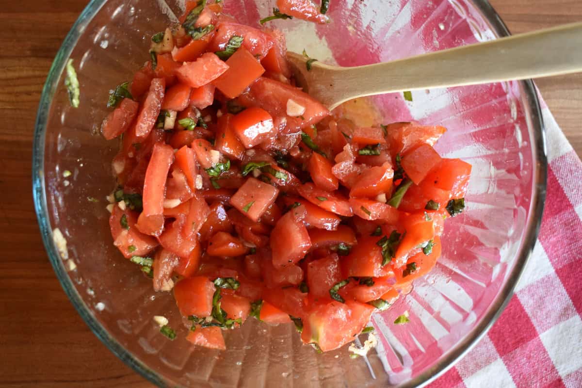 Raw Tomato Sauce in a glass bowl with a wooden spoon. 