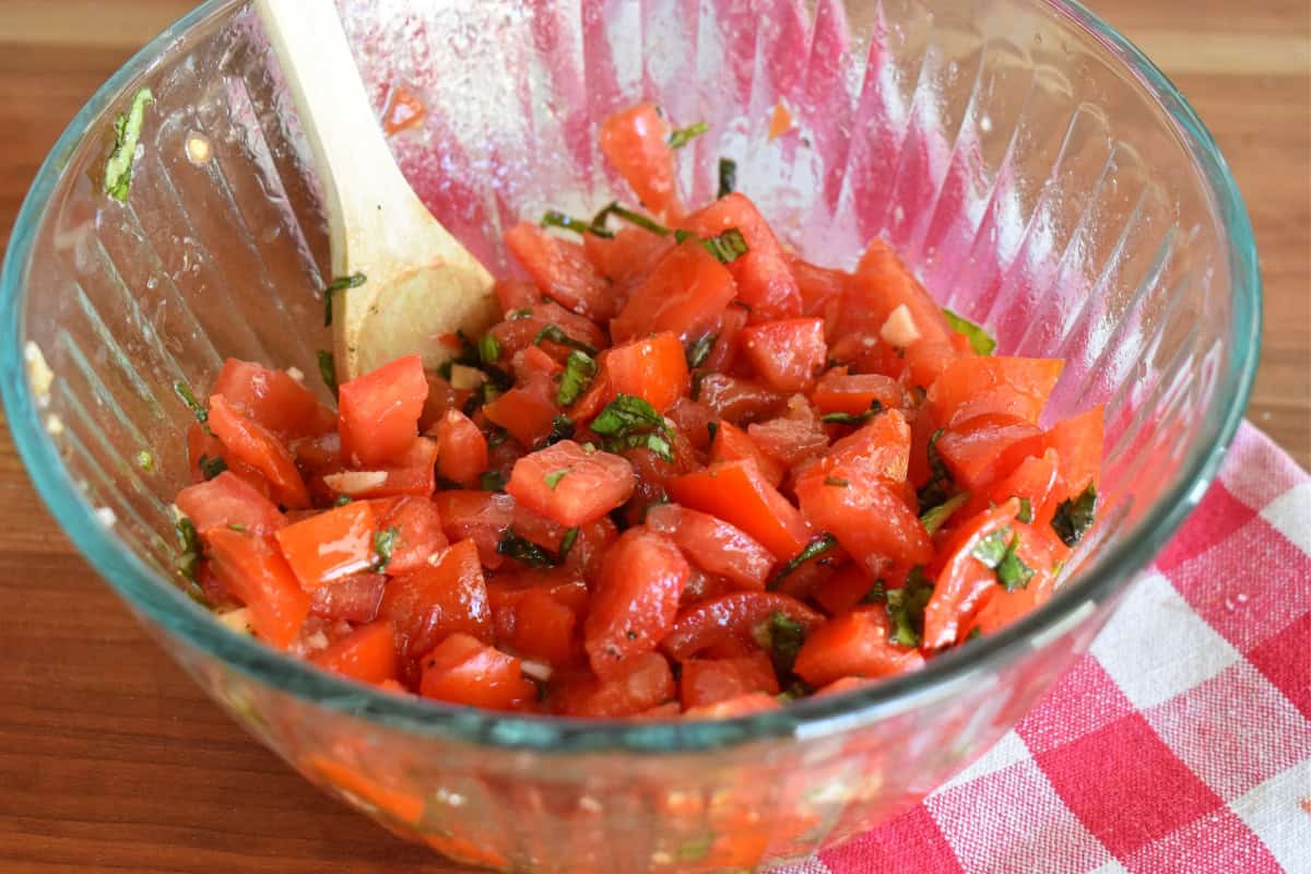 Raw tomato sauce in a glass bowl with a wooden spoon. 