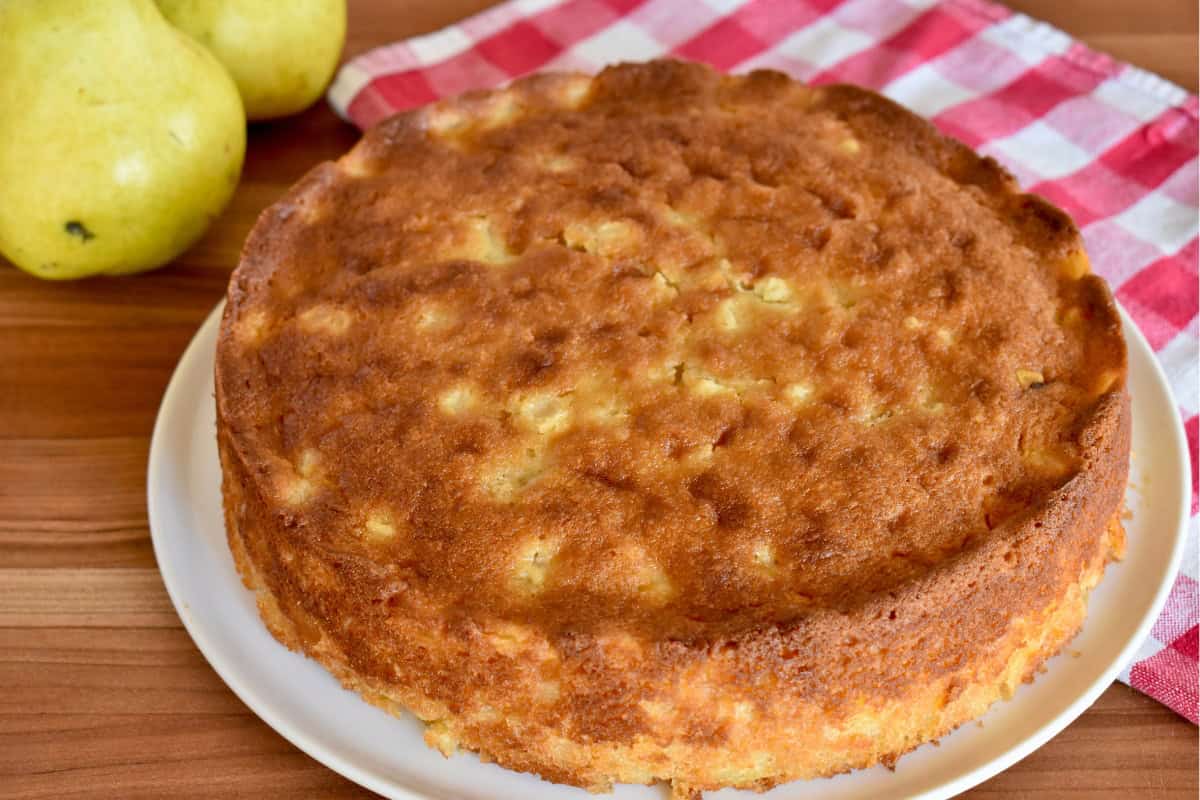 Baked pear ricotta cake on a white plate. 