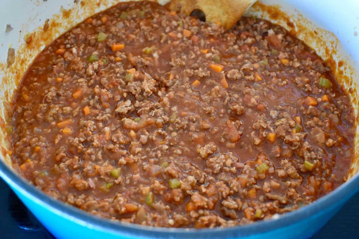 Tomato sauce added to the cooked meats and veggies in the dutch oven. 